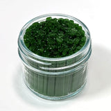 A glass jar filled with green, leaf-shaped objects, possibly candies or decorations.