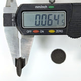 Digital caliper measuring the thickness of a powder wafer reading 0.064in