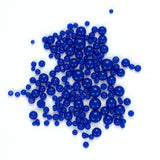 numerous small, round blue beads or buttons scattered across a white background.