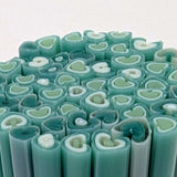a close-up view of numerous green and white cylindrical objects arranged in a circular pattern.