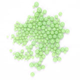 numerous small, round, green beads scattered across a white background.