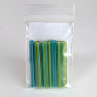 A clear plastic bag containing a collection of colorful, striped objects, likely a type of candy or small toy.
