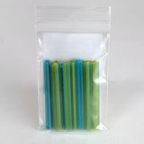A clear plastic bag containing a collection of colorful, striped objects, likely a type of candy or small toy.