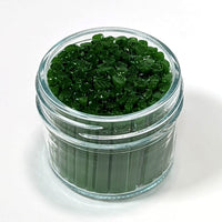 A glass jar filled with green, leaf-shaped objects, possibly candies or decorations.