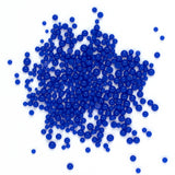 numerous small, round blue beads scattered across a white background.