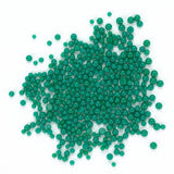 a large pile of green beads or spheres scattered on a white background.