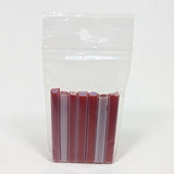 A clear plastic bag containing a row of red and white tubes or sticks.