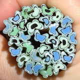 A hand holding a circular arrangement of colorful beads in shades of blue, green, and black.