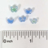 a collection of small, colorful beads arranged on a ruler for size comparison.