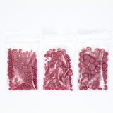 Three transparent plastic bags filled with red beads are arranged in a row against a white background.