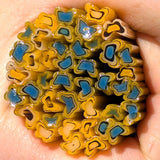 a close-up view of a hand holding a collection of colorful, multicolored beads or objects.