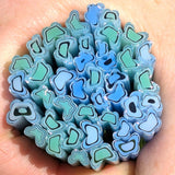 A close-up image of a hand holding a collection of colorful, abstract-shaped objects, likely made of glass or another material.