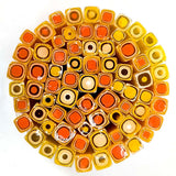 a circular arrangement of colorful glass tubes or rods, each with a unique shape and color, creating a visually striking and vibrant display.