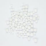 numerous small white beads scattered across a plain white background.