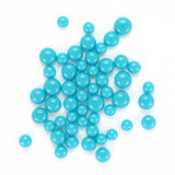 a collection of small, round, blue beads or spheres scattered across a white background.