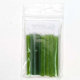 A clear plastic bag containing a set of green plastic tubes or sticks.
