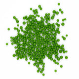 A cluster of green beads or spheres is scattered across a white background.