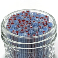 A glass jar filled with numerous small, colorful objects resembling flowers or other organic shapes.