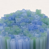 The image is a close-up of numerous blue and green glass tubes or rods, arranged in a visually striking manner.