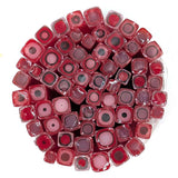The image is a circular arrangement of numerous red and pink glass tubes or containers, each containing a small black circle or dot.