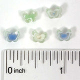 a collection of small, colorful beads arranged on a ruler for size comparison.