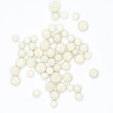 a collection of small, round, white beads or pearls scattered across a white background.
