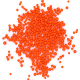 a large number of small, round orange beads or spheres scattered across a white background.