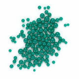 a collection of green beads scattered on a white background.