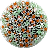 The image is a circular arrangement of various colored straws, including green and orange ones, creating a visually interesting and vibrant display.