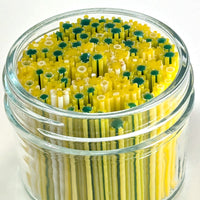 A glass jar filled with yellow and green straws, creating a colorful and playful arrangement.