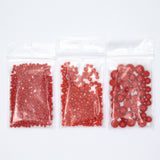 Three clear plastic bags filled with red beads are arranged in a row against a white background.