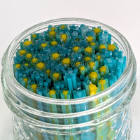 A glass jar filled with colorful, multicolored objects resembling flowers or plants.