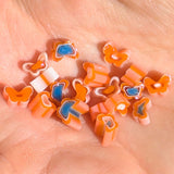 a hand holding a collection of colorful, small beads in various shapes and colors, including orange, blue, and pink.