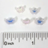 a collection of small, colorful beads arranged on a white background, with a ruler for scale.