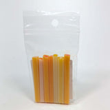 A clear plastic bag containing a row of small, cylindrical objects in various shades of orange and yellow.
