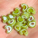 a collection of green heart-shaped objects, possibly made of a material that resembles plastic or paper, arranged on a surface.