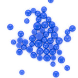 numerous small, round blue beads scattered across a white background.