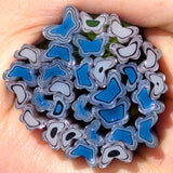 a close-up view of a hand holding a collection of colorful, abstract glass or ceramic shapes resembling flowers or leaves.