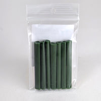 A clear plastic bag containing a set of green wax sticks.
