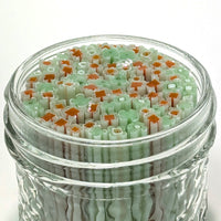 A glass jar filled with colorful, multicolored objects, such as small cubes or shapes, creating a visually striking and vibrant display.