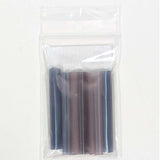 A clear plastic bag containing several small, cylindrical objects, which appear to be some sort of plastic tubes or tubes with a purple and blue color scheme.