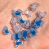 a close-up view of a person's hand holding a collection of small, colorful beads in shades of blue and white.