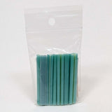 A clear plastic bag containing a row of green and blue cylindrical objects.