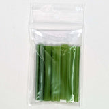 A clear plastic bag containing a group of green plastic tubes or sticks.