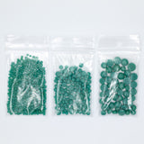 Three clear plastic bags filled with green beads are arranged in a row against a white background.