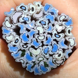 A close-up image of a hand holding a circular arrangement of blue and white glass beads or beads with a unique, abstract pattern.