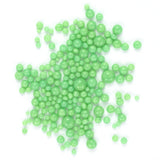 numerous small, round, green beads scattered across a white background.