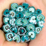 A close-up image of a hand holding a collection of colorful, spiral-shaped objects in shades of blue and green.