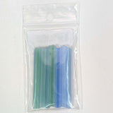 A clear plastic package containing a set of colored plastic tubes, with the tubes being green and blue.