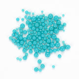 numerous small, round, turquoise-colored beads or stones scattered across a white background.